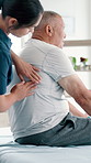 Physiotherapy, senior man and back pain with doctor support, healthcare service and physical therapy in clinic office. Physiotherapist or chiropractor with patient for muscle, massage or consultation