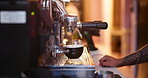 Hands, machine and barista making coffee at cafe, process and professional service in small business. Closeup, portafilter and waiter with cup to prepare espresso drink, pour latte and hot cappuccino