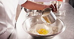 Hands, eggs or pouring milk in flour on table, chef or process of dough wheat on kitchen counter. Baker, working and wet to dry ingredients for french bread, hospitality and culinary cooking in hotel