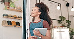 Tablet, small business and barista at door of coffee shop with positive, good and confident attitude. Happy, thinking and young female waitress with digital technology at cafeteria or restaurant.