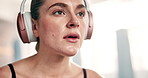 Fitness, headphones and woman in gym breathing on break from workout to relax with streaming service. Music, rest and tired girl at exercise club with health, wellness and earphones in power training