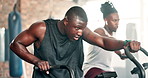 Fitness, cardio and black man on machine in gym for intense workout, training and exercise for healthy body. Sports, sweating and people on cycling equipment for performance, endurance and wellness