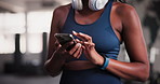 Phone, fitness and closeup of woman in gym networking on social media, mobile app or internet. Sports, technology and African female athlete typing online email on cellphone in health studio.