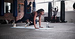 Black woman, fitness and mountain climber exercise on floor mat at gym for fitness, workout or training. Young African female person or athlete in core strength, ab muscle or balance at health club