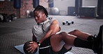 Black man, medicine ball and fitness on floor for exercise, workout or training at gym. Active African male person in crunches for muscle, strength or endurance in practice for stamina at health club