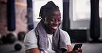 African man, phone and texting in gym with smile for notification, chat or web blog for training. Person, smartphone and laugh for reading on app for exercise, workout or social media at fitness club