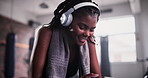 Woman, smartphone and headphones in gym for dancing, music or choice for internet radio at training. African person, phone or happy dancer with listening to audio streaming subscription on mobile app