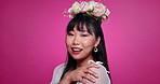 Pink background, beauty and face of Asian woman with flowers for wellness, confidence and smile. Salon aesthetic, floral crown and portrait of person for natural cosmetics and skincare in studio