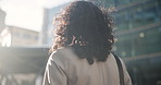Businesswoman, back view and buildings outdoors with walking for morning travel, journey or commute to workplace. Professional person, outdoors and daily movement to office, corporate or career