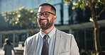 Happy, businessman and city in success for career ambition, fashion or style by outdoor building. Portrait of young man or employee smile with glasses for smart, job or positive mindset in urban town