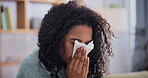 Female person, sick and sneeze at home, sofa and blanket to relax, recover and keep warm from winter season. Woman, flu and tissue with throw, couch and pillow at the house to isolate and cough