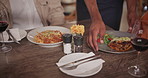 Waiter, restaurant and hands with food, man and woman at table on date Italian cuisine with wine. Closeup, lasagne and date at bistro with spaghetti, pasta and table for dinner or lunch service