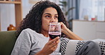 Depression, wine and drunk with bored woman on sofa in living room of home to relax or drink. Sad, frustrated or unhappy and young alcoholic person drinking in apartment with mental health problems