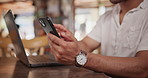 Hands, phone and man in coffee shop networking on social media, mobile app or the internet. Laptop, technology and closeup of male person typing online email or text message with cellphone in cafe.