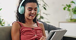 Woman, headphones and tablet on sofa with scroll for social media search or online shopping with music, audio or relax. Female person, happy and subscription for web streaming,  network or multimedia