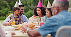 Family, eating and happy with hat at birthday party for celebration, surprise or conversation in garden of home. Couple, parents and kids with drinks for gathering and event in backyard of house