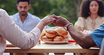 Holding hands, prayer and food with thanks, religion and backyard with family and lunch. Faith, worship and praying at a table for blessing together on a patio outdoor from a home at a gathering