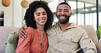 Happy couple, hug and relax on living room sofa for bonding, love or care together at home. Portrait of young man and woman sitting on couch with smile for holiday, weekend or relationship at house