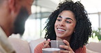 Happy couple, coffee and conversation to relax on sofa in home living room with listening, chat and connection. Woman, man and tea cup with talking, love and bonding with care at house in Colombia