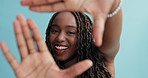 Happy, black woman and hands in frame for picture, selfie or photography in style or fashion on a blue studio background. Portrait of African female person framing face, smile or hairstyle for photo