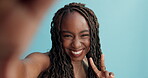 Black woman, face and selfie with happiness, peace hand sign and social media with emoji on blue background. Portrait, influencer and content creation for website, live streaming and V in a studio