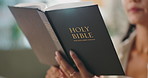 Hands, reading and woman with bible at her home for worship, religion or spiritual wellness. Praise, healing and closeup of female person studying holy book for christian faith and peace in apartment