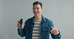 Happy man, dance with earpods and smartphone for music, fun and energy in studio with laughter on grey background. Mobile app for entertainment, tech for moving with rhythm and listening to radio