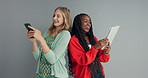 Women, friends and studio with tablet, phone and laughing at meme with diversity by background. Girl, people and technology for network connection with mobile app, social media and happy on internet