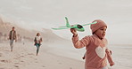 Parents, children and beach with plane, toys and girl with smile for running, game pr flight on holiday. Family, water and kids with airplane for bonding, care or playful by sea with love on vacation