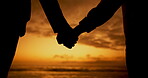 Sunset, silhouette and couple holding hands at beach for love, care and bonding on holiday. Shadow, man and closeup of woman at ocean for romantic date, vacation and support in relationship together