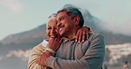 Senior couple, hug and happy at beach with love, care and connection by mountains on vacation. Elderly man, old woman and people for romance, memory and outdoor with smile on holiday in Cape Town
