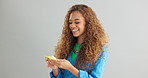 Happy woman, typing and networking with phone for social media or communication on a gray studio background. Female person or model with smile on mobile smartphone for online chatting on mockup space