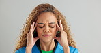 Frustrated woman, headache and stress with anxiety, mental health or depression on a gray studio background. Face of tired female person in fatigue, pressure or tension with overwhelmed emotion