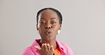 Face, happy and black woman with air kiss in studio for thank you gesture on grey background space. Portrait, hands and African female model with palm emoji for love, kindness or flirting expression