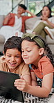 Happy children, siblings and tablet with family for entertainment, bonding or streaming at home. Young kids, boy and girl enjoying games, movie or cartoons with technology in living room at the house