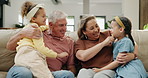 Children, grandparents and conversation on sofa as family for relax connection for weekend, day off or bonding. Girls, old couple and communication on couch in apartment for resting, care or holiday