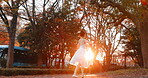 Nature, sunset and ballet woman in a park practicing for a concert, show or classical theater. Art, elegant and Japanese female ballerina in rehearsal with music at outdoor garden or field in Autumn.