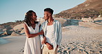 Couple, love and walking on beach in summer with conversation, bonding and holiday or valentines day. Young african woman and man talking, holding arms and happy vacation in Cape Town, South Africa