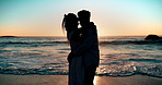 Love, beach and couple hug at sunset together for bonding, relax and relationship. Dating, travel and silhouette of man and woman embrace by ocean for romantic holiday, vacation and weekend in nature