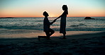 Sunset, proposal and couple at a beach with love, question or surprise romantic gesture in nature. Engagement, asking and silhouette of people at sea with support for marriage, future or commitment