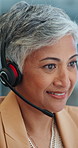 Senior woman, face and consultant with headphones at call center for customer service at office. Closeup of mature female person or agent with smile and talking for online advice or help at workplace