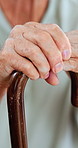 Cane, senior and hands in home for retirement, osteoporosis and balance in house. Walking stick, closeup and elderly person with a disability, injury and crutch to help with support for mobility