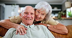 Smile, face and senior couple in living room relaxing on sofa and bonding together at home. Happy, love and portrait of elderly woman embracing husband in retirement with care in lounge at house.