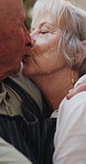 Senior, couple and kiss in kitchen with love, support and care in marriage and retirement. Elderly, man and woman embrace with kindness or gratitude for cooking dinner in home together with happy hug