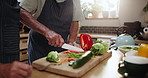 People, hands and cutting vegetables with board for food preparation, diet or healthy meal in the kitchen. Closeup of person, chef or cook with natural slices of organic green salad for snack at home