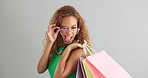 Woman, glasses and shopping bag in studio for fashion sale, discount and luxury with vision or eye care. Face of a young african person or happy model with cool and trendy style on a white background