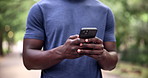 Phone, hands and fitness man in a park with social media, chat or location search in nature. Smartphone, closeup or male runner in forest online for navigation app, internet or exercise blog update
