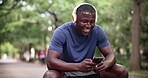 Man, cellphone and headphones for outdoor workout with laughing for funny podcast, humor or fitness. Black person, sweat and texting conversation for park exercise as runner rest, streaming or music