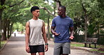 Men, friends and talking on walk in park for athlete workout or bonding conversation, cardio or wellness. Male people, healthy and relax on forest street in Australia for training, chat or together