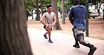 Instructor, men and squat outdoor for fitness with exercise, workout or coach in nature with talking. Personal trainer, athlete or training in park before cardio for wellness, routine or healthy body